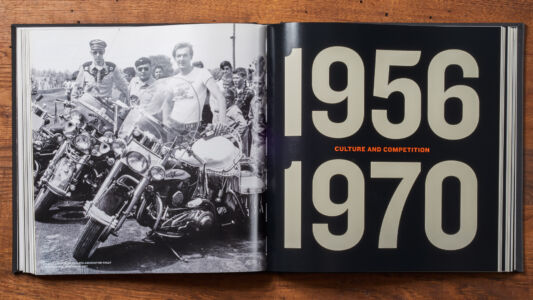The cover of the book.
(956 CULTURE AND COMPETITION 1970,people, retro, no person, vintage, education, text, business, print, man, bill, school, leader, adult, music, squad, technology, desktop, teamwork, one, wear)